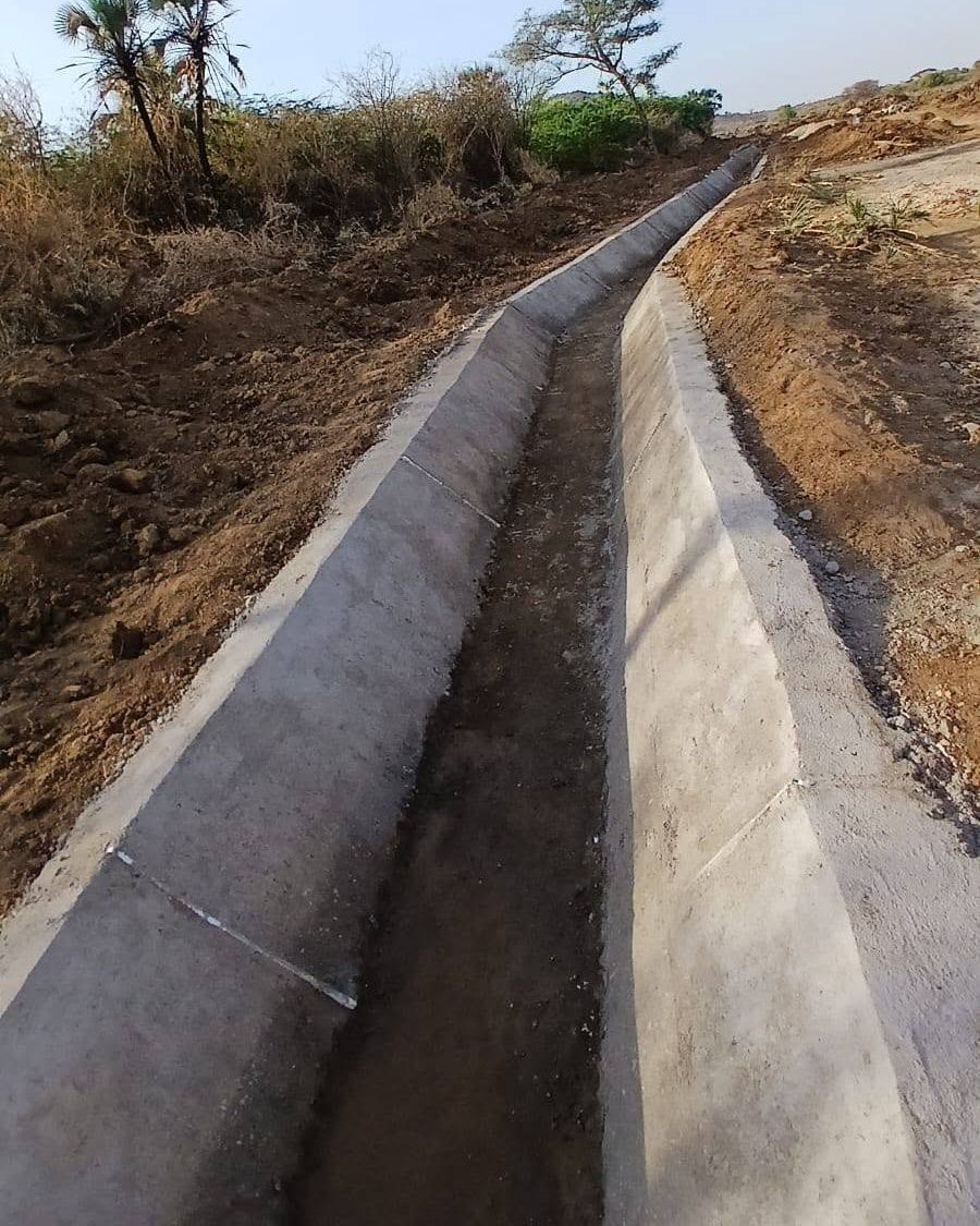 A finished concrete-lined canal running into the distance.